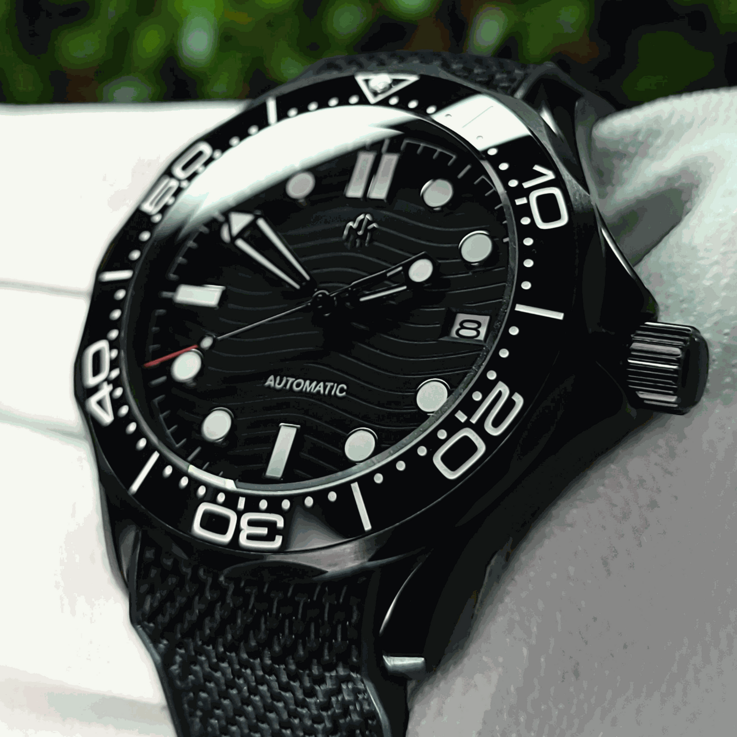 A Seiko Mod Omega Seamaster with a Black Dial being held in a white gloved hand