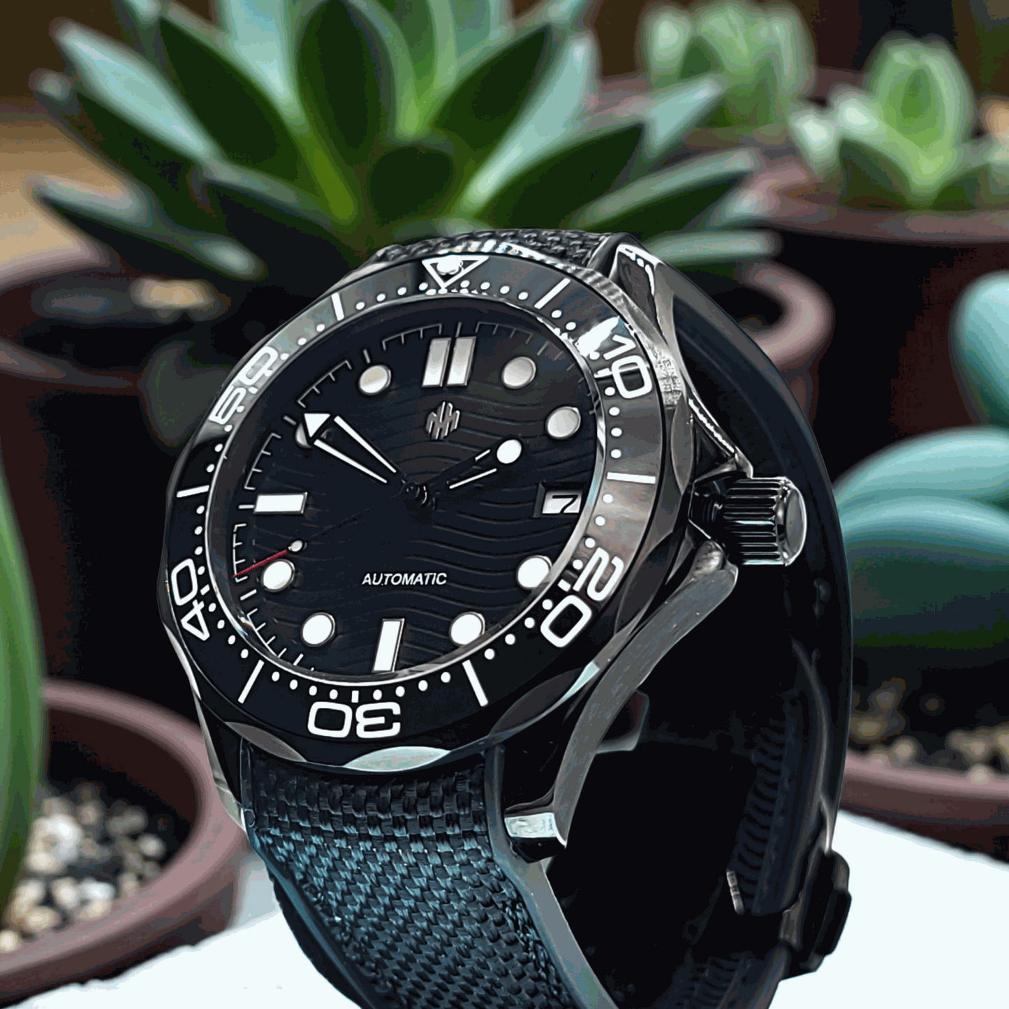 A Seiko Mod Omega Seamaster with a Black Dial o. A table with succulents