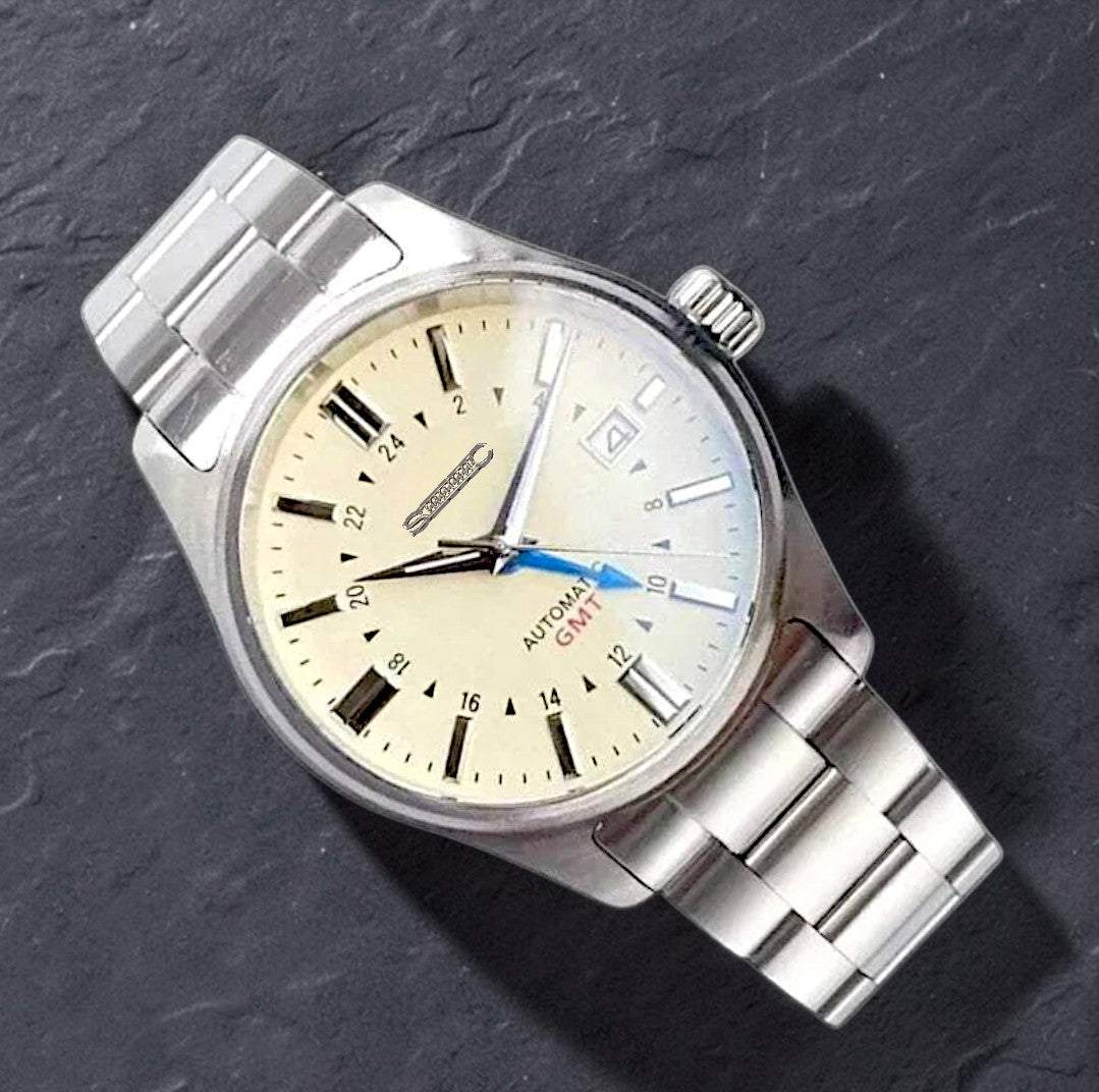 MODTIME custom GMT automatic pilot watch with a cream dial, stainless steel case, and blue GMT hand on a slate surface.