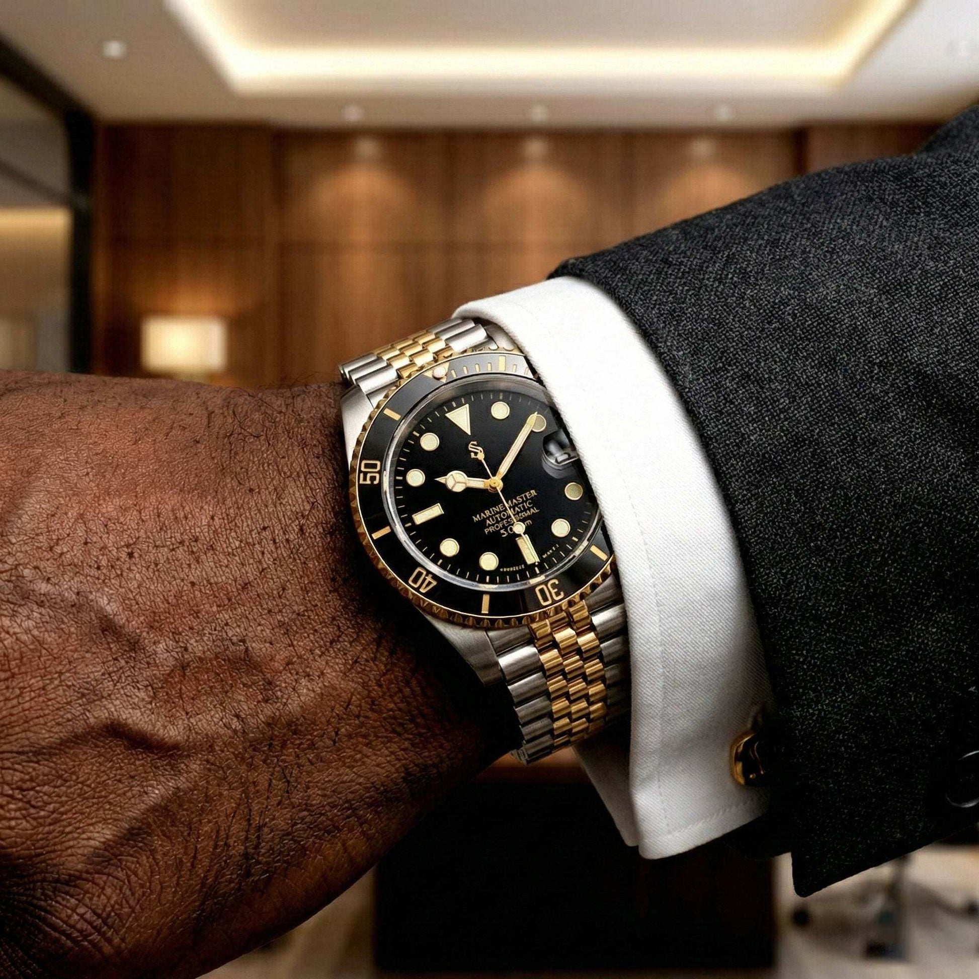 MODTIME SeikMariner black and gold two-tone diver watch with stainless steel bracelet worn on a man's wrist