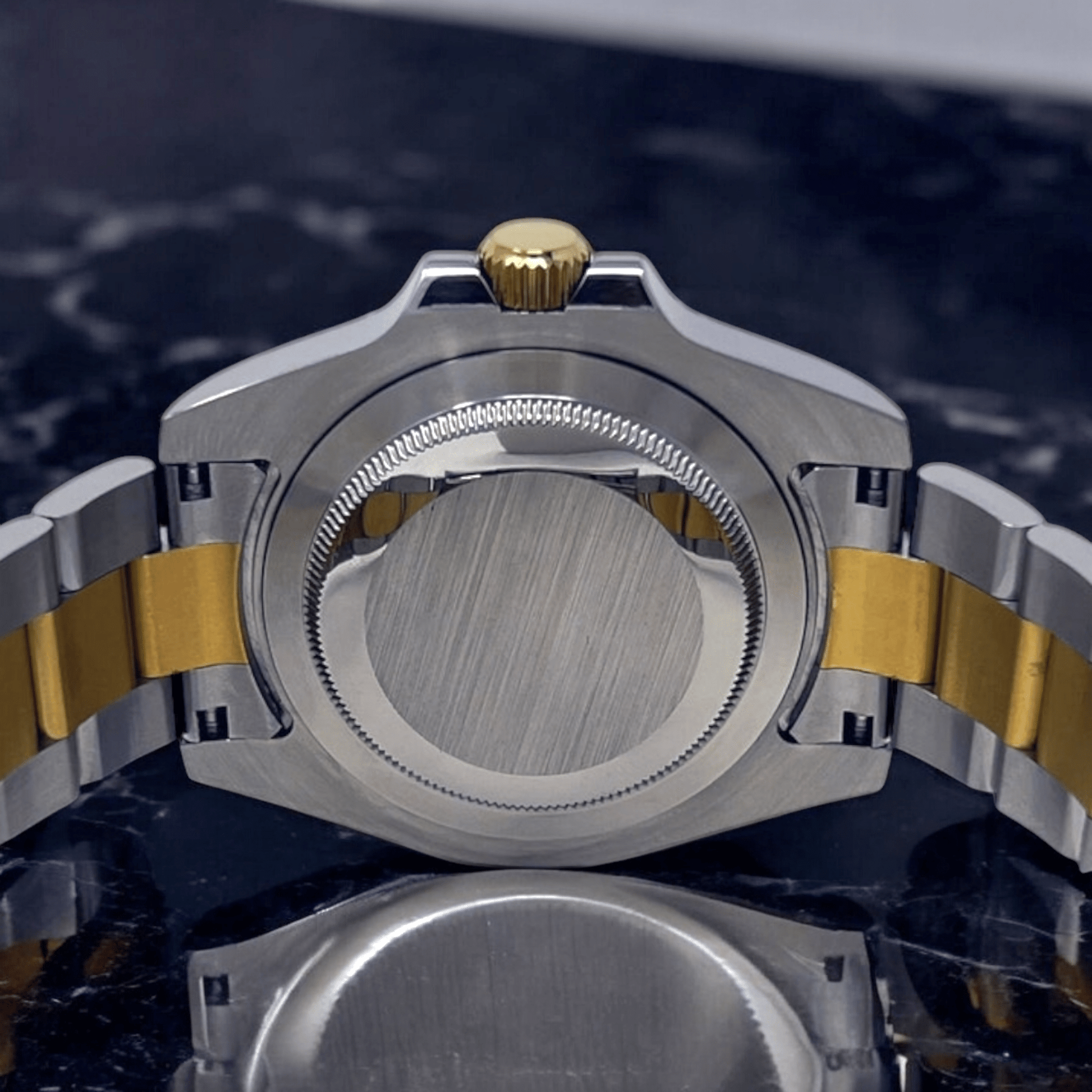 MODTIME SeikMariner two-tone diver watch showing the stainless steel case back, gold crown, and bracelet links.