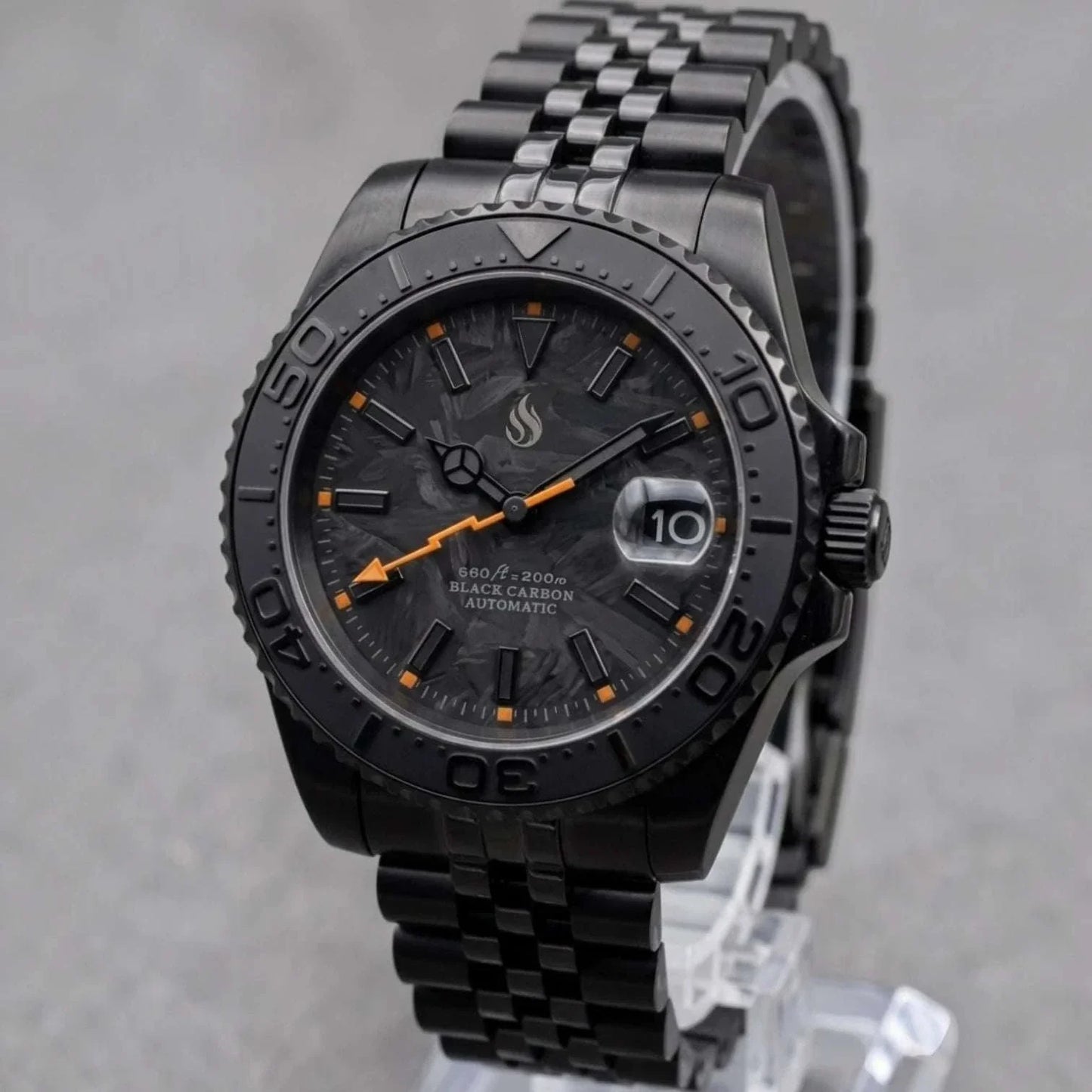 Seiko Mod watches. A close-up of a custom black carbon automatic Yachtmaster watch with a textured black and orange strap, featuring a dark dial and date window. 