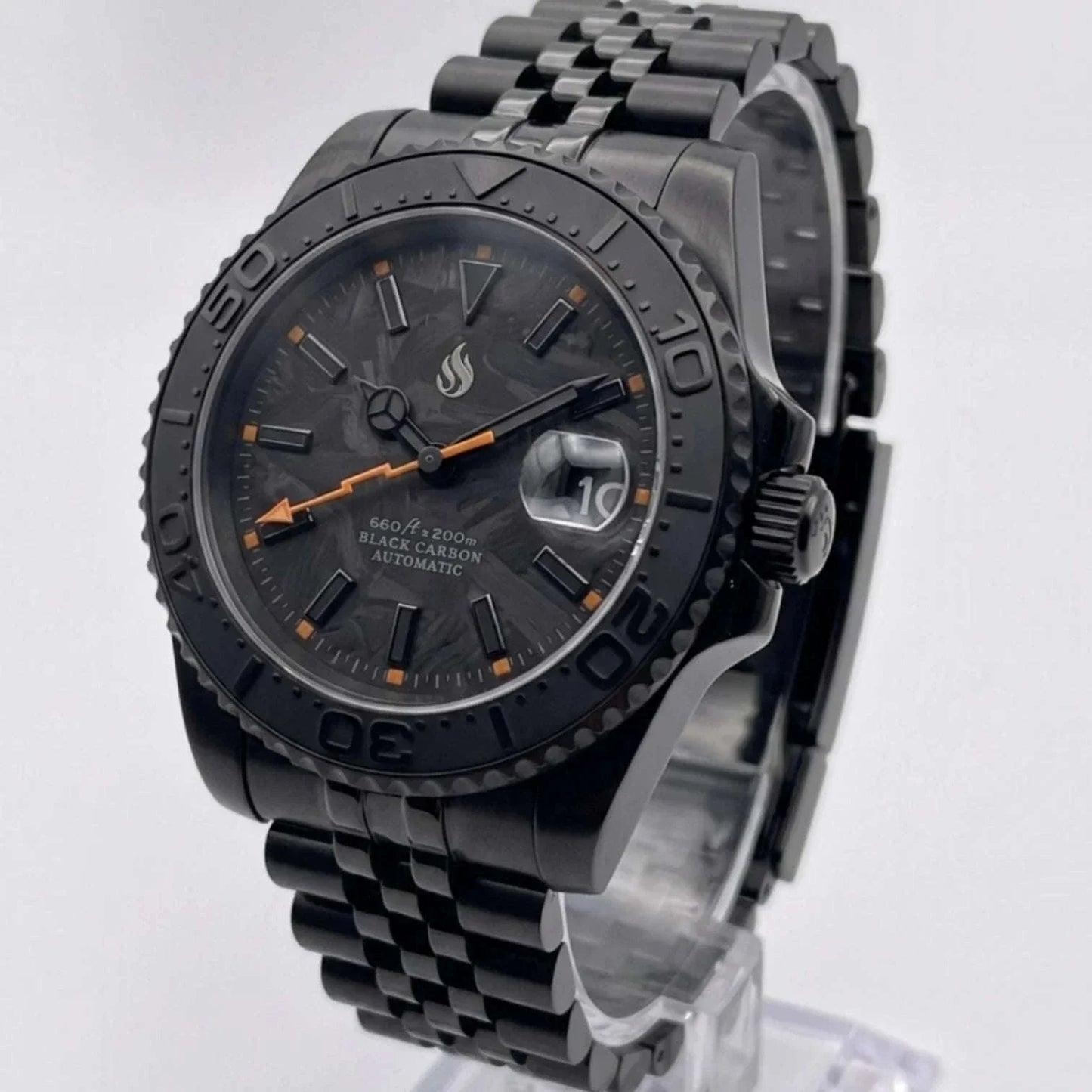 Seiko Mod watches. A black carbon automatic Yachtmaster watch with a black bezel, black link bracelet, and orange accents on the dial, displayed on a clear stand against a light gray background.