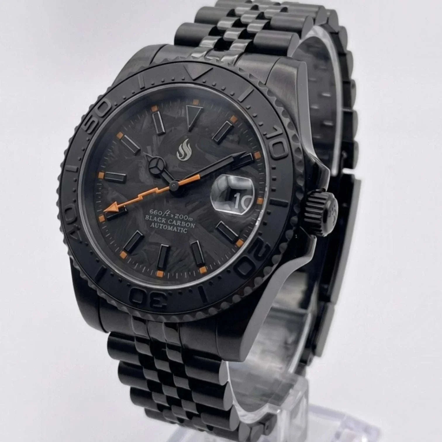 Seiko Mod watches. A black carbon automatic Yachtmaster watch with a black bezel, black link bracelet, and orange accents on the dial, displayed on a clear stand against a light gray background.